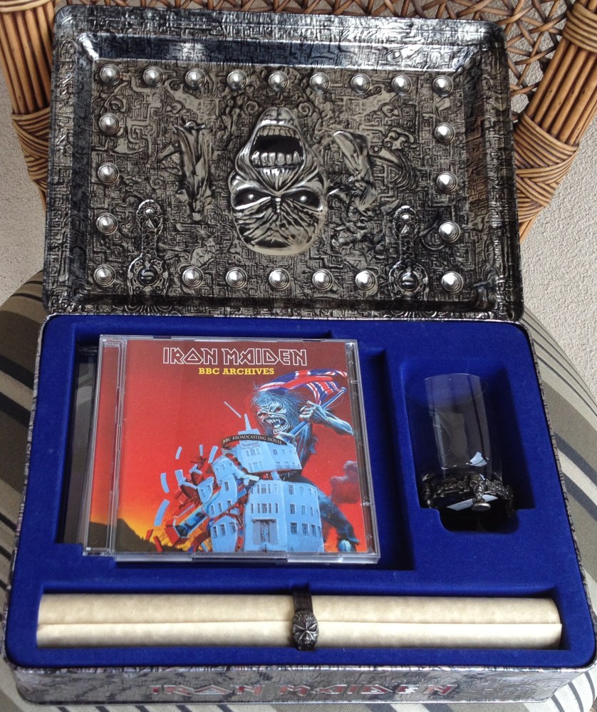 Abrindo-se a caixa, é possível apreciar o itens devidamente alojados em um bonito revestimento aveludado. Os CDs ficam colocados em 3 níveis onde, pela cor, é possível entender qual é qual. Ao lado, o copinho (que serve também como porta-velas) e a "árvore genealógica" da banda com um anel do Eddie também em metal
